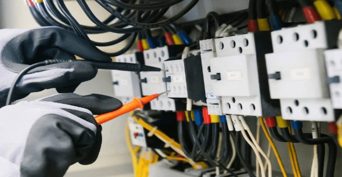盤内の端子と配線を工具で確認する電気設備工事の手元